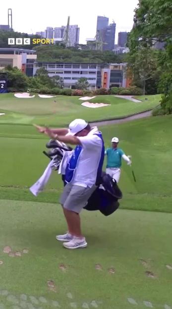 A golfer and his caddy react after making an incredible shot.