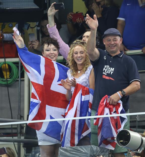 Adam Peaty's family and girlfriend cheering in the stands with British flags at the Rio 2016 Summer Olympics.