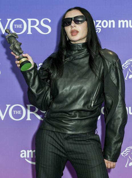 Charlie XCX holds her Songwriter of the Year award.
