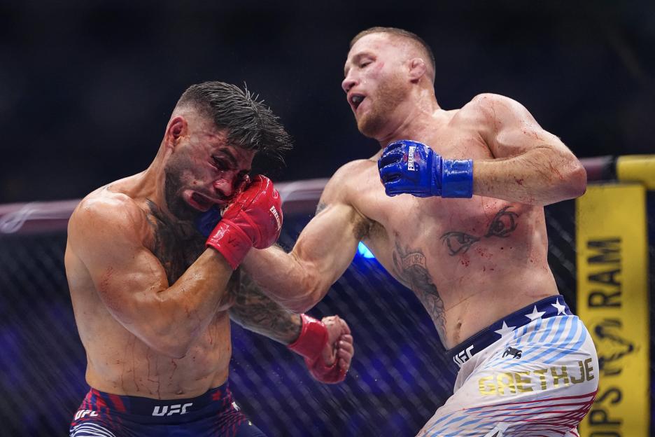 Justin Gaethje striking Ilia Topuria in an MMA fight, both fighters covered in blood.