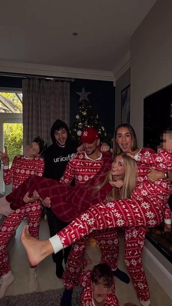 Peter Andre and his family posing in front of a Christmas tree while wearing matching holiday pajamas.