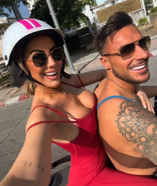 Chloe Ferry and Alex Swinney taking a selfie while riding a motorcycle in Thailand.
