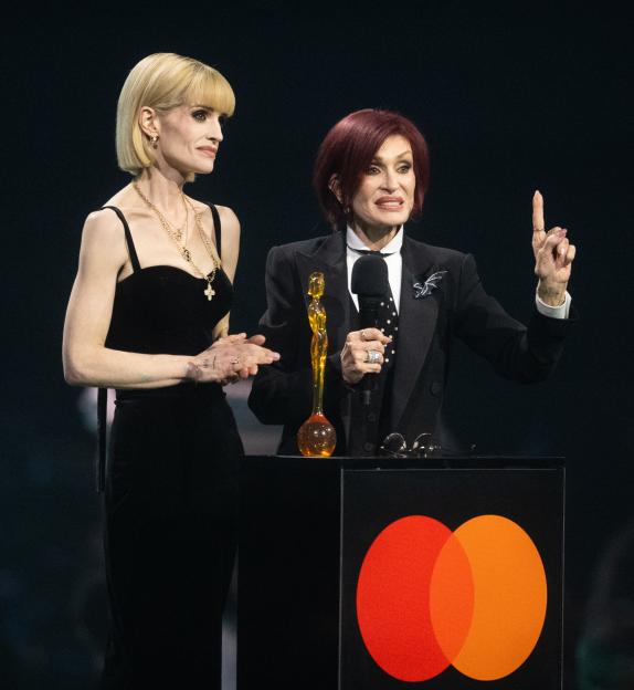 Kelly Osbourne and Sharon Osbourne accept the Lifetime Achievement Award for Ozzy Osbourne on stage at the BRIT Awards 2026.