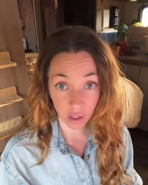 A woman with brown hair, wearing a denim shirt, with the word “Kentucky” written on it.