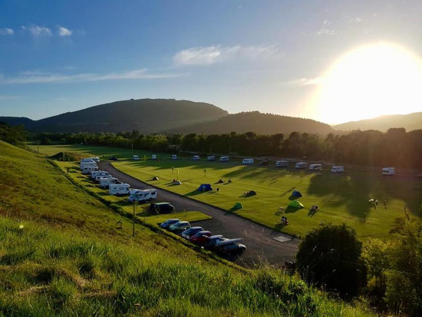 Loch Ness Bay Campsite in Drumnadrochit with RVs, tents, and cars.