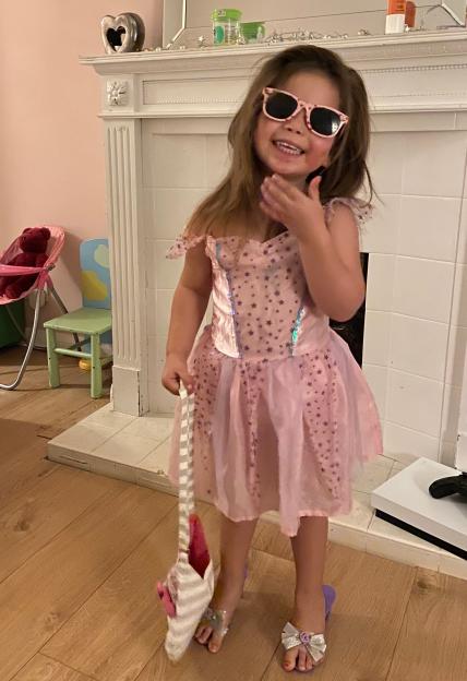 Primrose Hocking in a pink princess dress, sunglasses, and high heels.