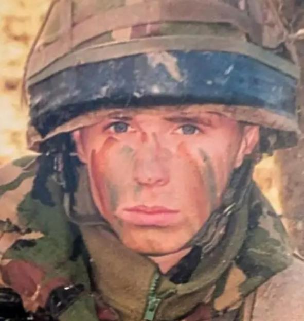 Simon Miller, an Afghan war veteran, in military uniform and camouflage face paint.