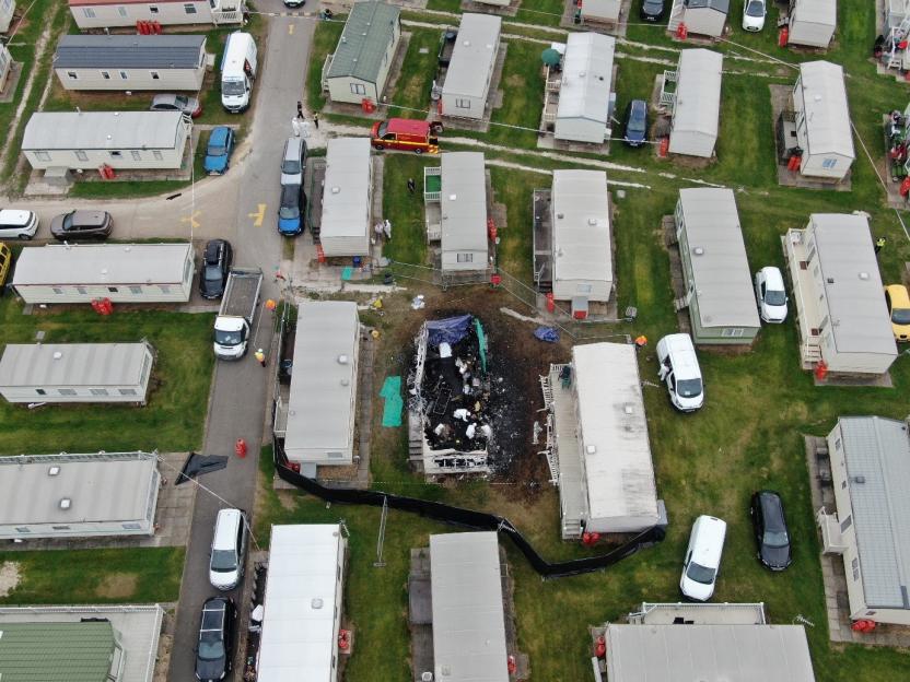 Aerial photo showing the aftermath of a devastating caravan fire in a holiday park.