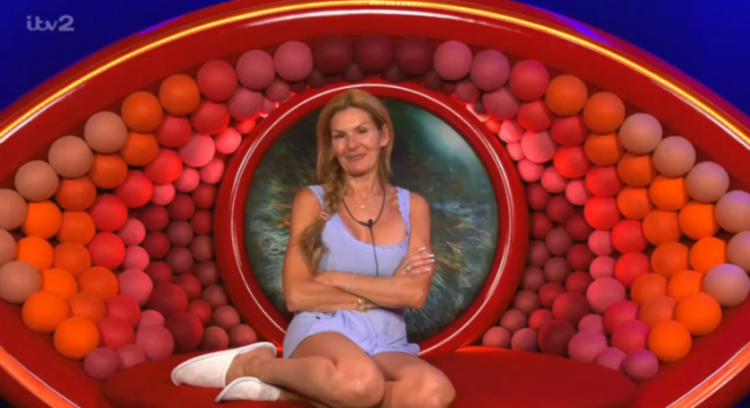 A woman in a blue top and shorts sits with crossed arms inside the Big Brother eye logo, with ITV2 visible in the top left corner.