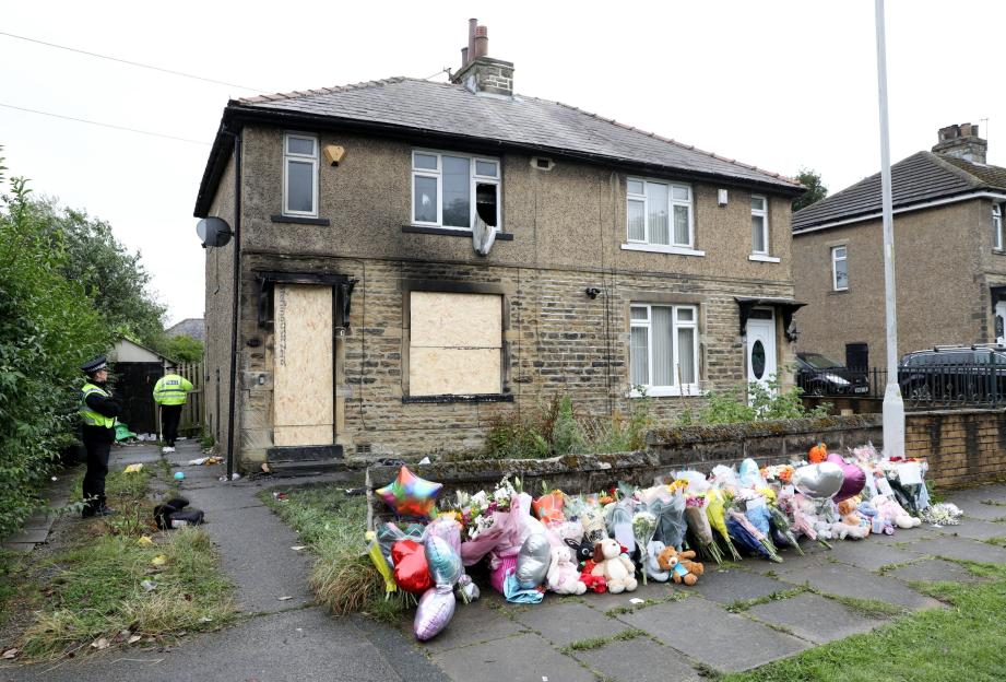 Memorial outside a house with burn marks