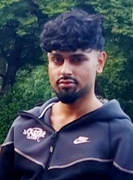 Ismail Younis, a young man with curly dark hair and a beard, wearing a dark blue zip-up jacket.