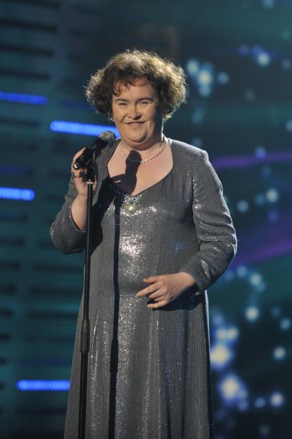 Susan Boyle singing into a microphone on stage.