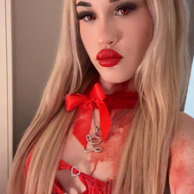 Larisa Sumovskaja in costume with red lipstick, red eyes, a red bow, and fake blood on her chest.