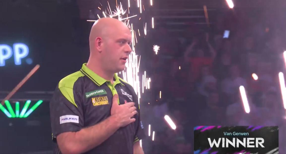 Darts player Michael van Gerwen with his hand on his chest, with sparks flying in the background, and a "Winner" graphic.