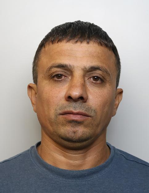 Mugshot of Abdulmanon Aliev, a man with short brown hair, wearing a dark blue t-shirt, looking directly into the camera.
