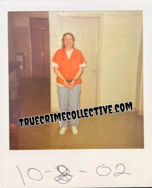 Aileen Wuornos in an orange jumpsuit with handcuffs, smiling.