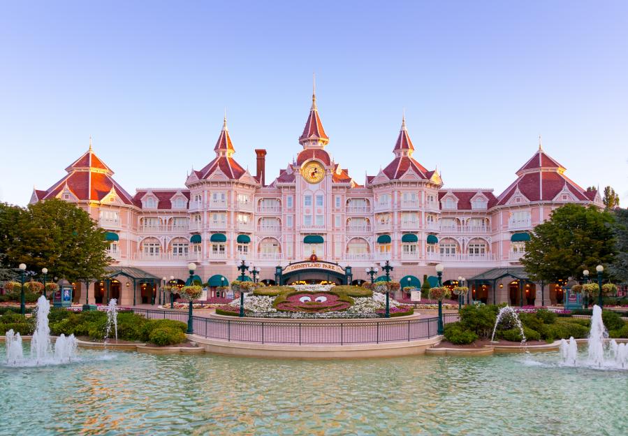 Disneyland Paris Hotel entrance, seen from across a fountain-filled pond.