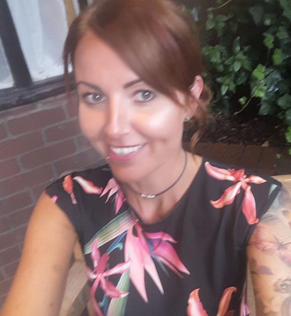 Rebecca Williams, a woman with auburn hair and a floral top, smiling.