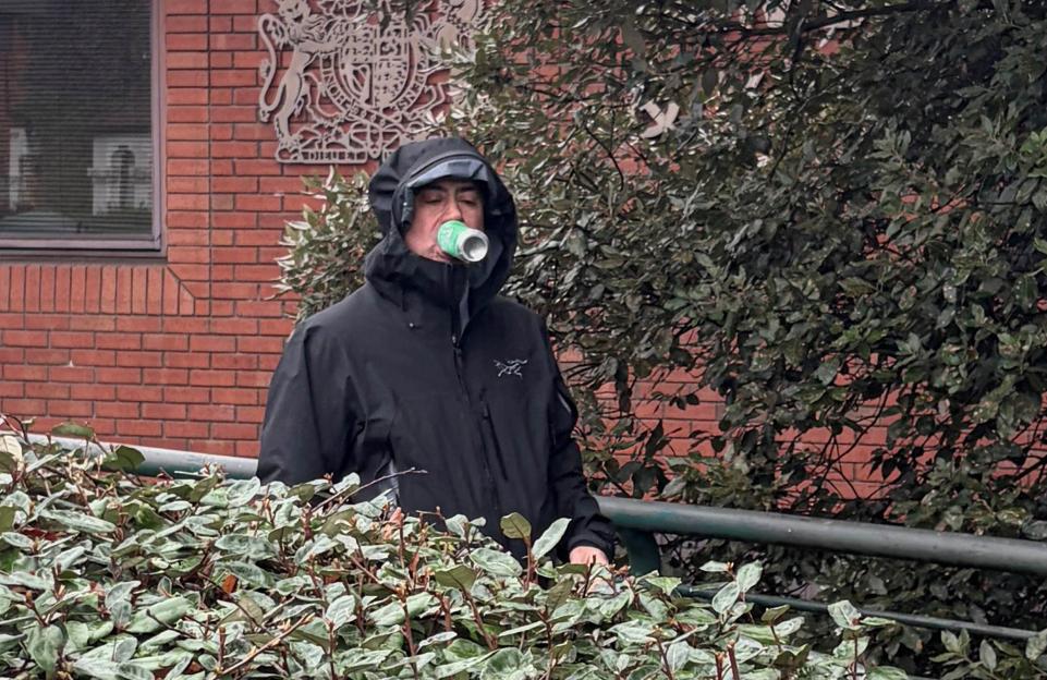 Dr. Martin Kuper leaving Wimbledon Magistrates' Court, taking a drink from a can.