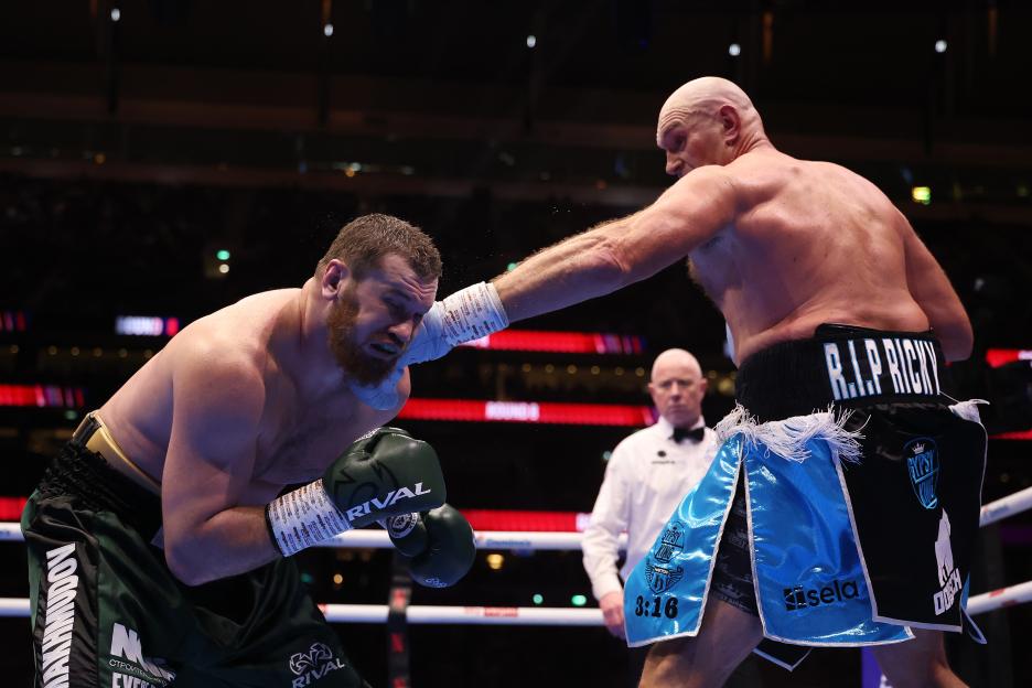 Tyson Fury punches Arslanbek Makhmudov during a heavyweight boxing match.