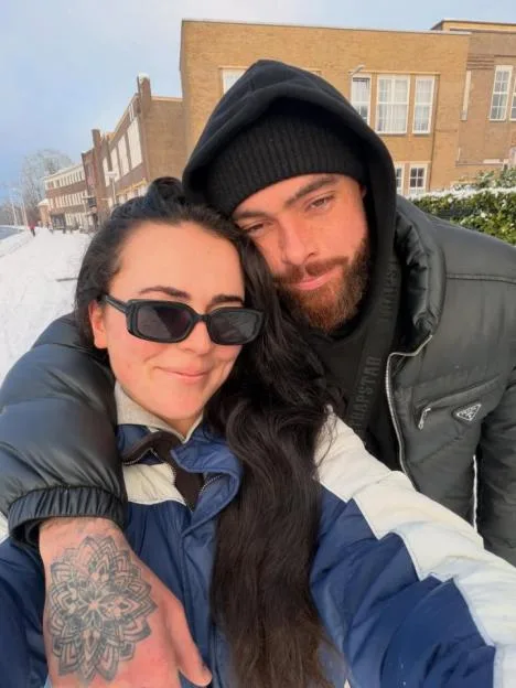 Lydia Rodford and her partner smiling together outdoors in the snow.