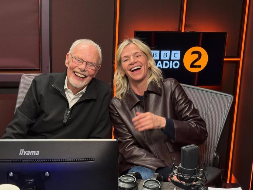 Bob Harris and Zoe Ball laughing in a radio studio.