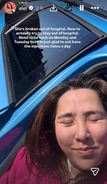 Michelle Elman smiling with eyes closed in a car, celebrating being out of the hospital after emergency surgery.