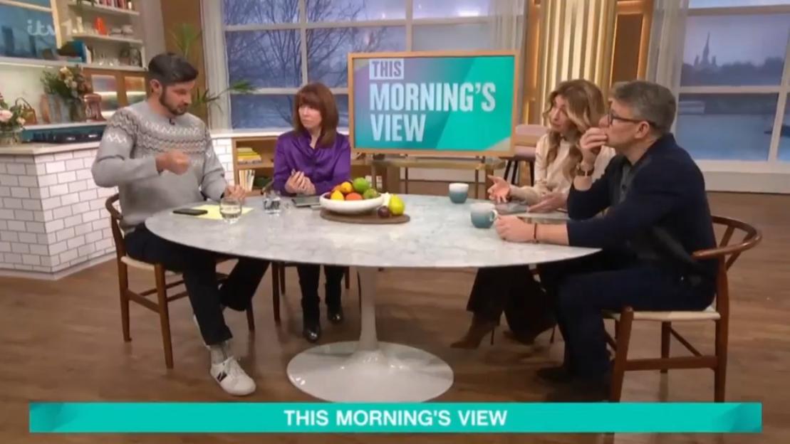 Four people sitting around a table with a "This Morning's View" sign in the background.