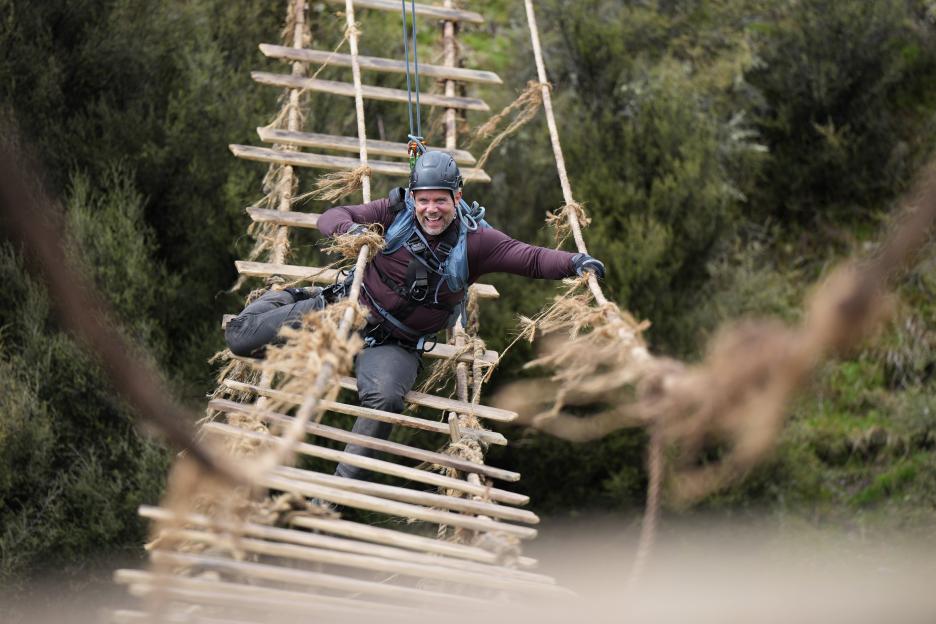 Warren navigating a suspended rope ladder.