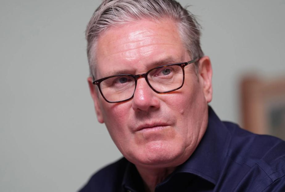 Sir Keir Starmer wearing glasses and a dark blue shirt.