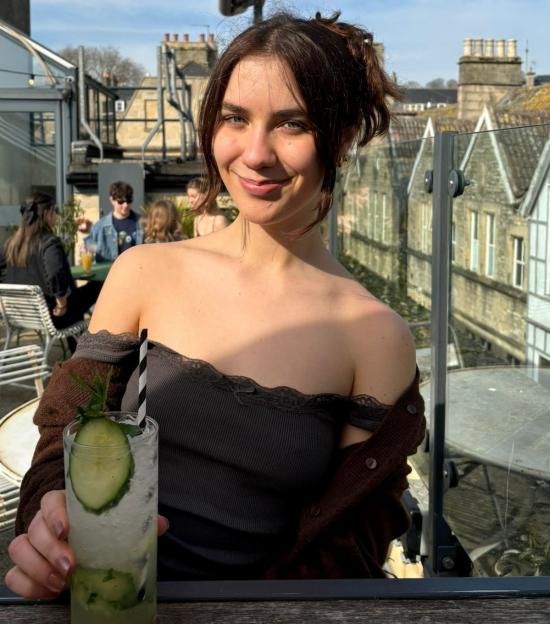 Gabriella Goddard, a 22-year-old woman with £100,000 in savings, smiling and holding a drink.