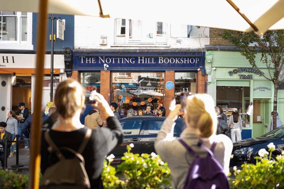 The Notting Hill Bookshop and Doughnut Time storefronts, with people in the foreground taking photos.