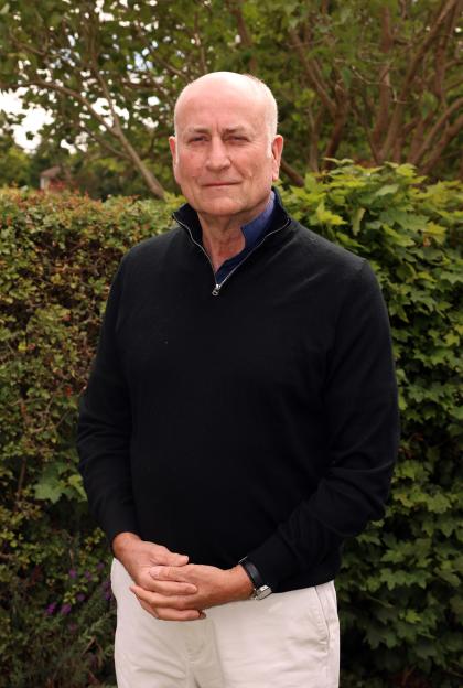 Grenville Long, a local resident of RAF Linton-on-Ouse, standing outdoors with green foliage behind him.