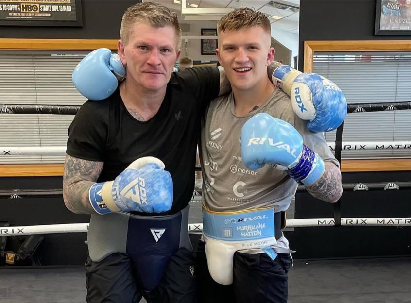 Ricky Hatton and his son Campbell wearing boxing gear in a ring.