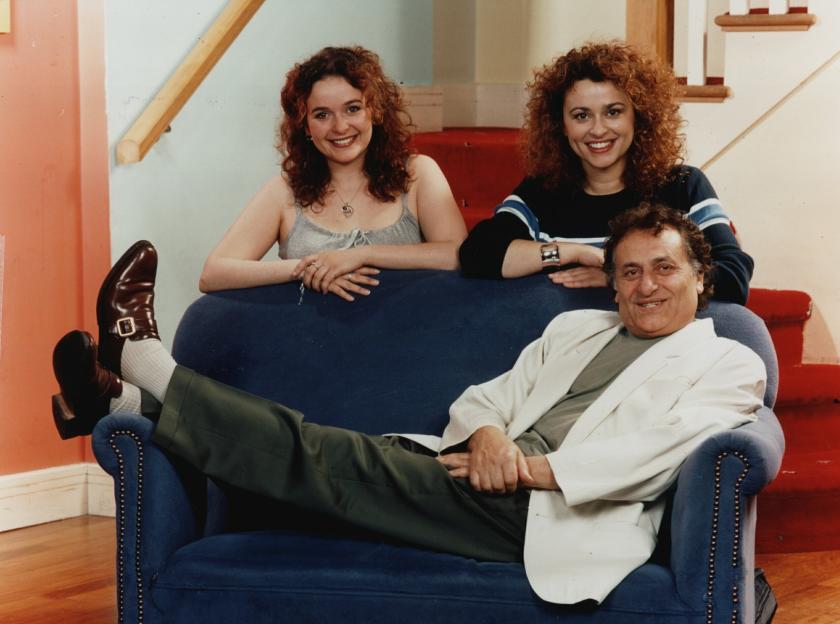 Nadia Sawalha, Julia Sawalha, and their father Nadim Sawalha posing together on a blue sofa.