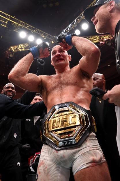 Sean Strickland celebrates his split-decision victory, wearing the UFC middleweight championship belt.