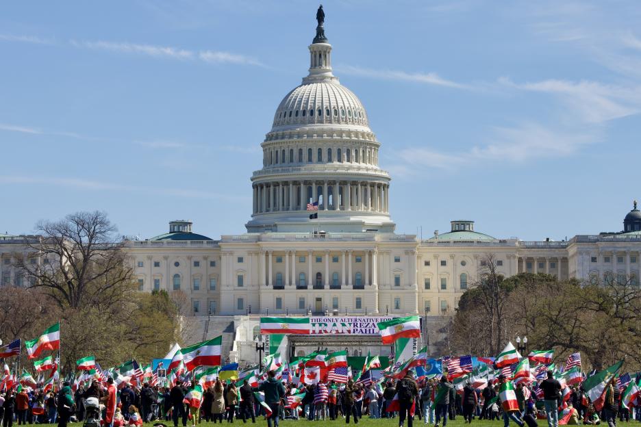 Demonstrators holding Iranian and American flags rally in front of the US Capitol Building.