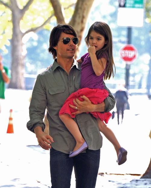 Tom Cruise carrying Suri Cruise in a park.