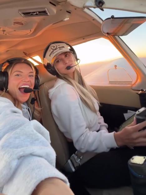 Kinsey Wolanski wearing headphones and a floral dress while piloting a small plane.