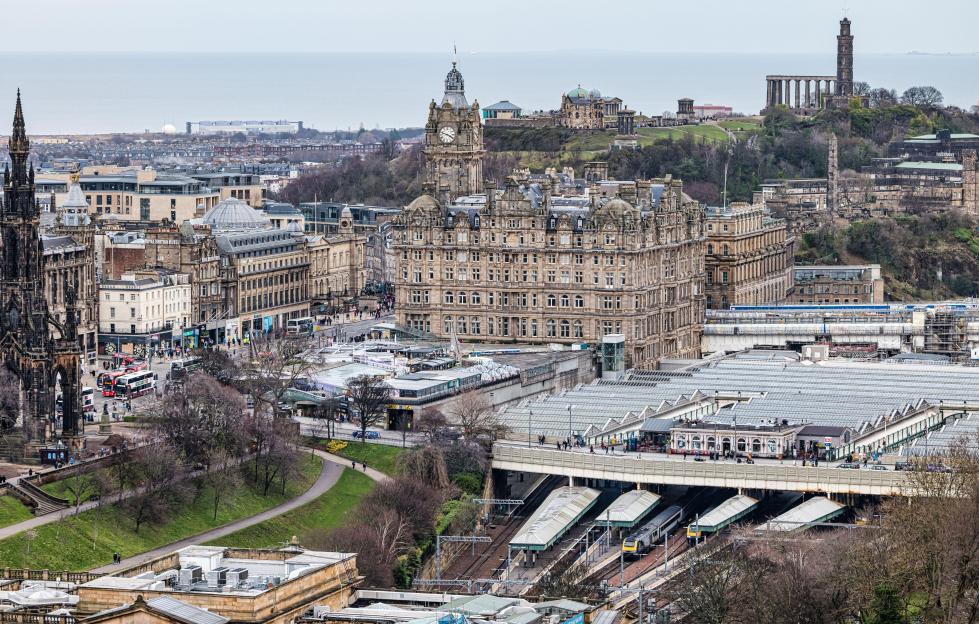 Aerial view of Edinburgh, Scotland, showing the Balmoral Hotel clock tower, Calton Hill, and Waverley railway station.