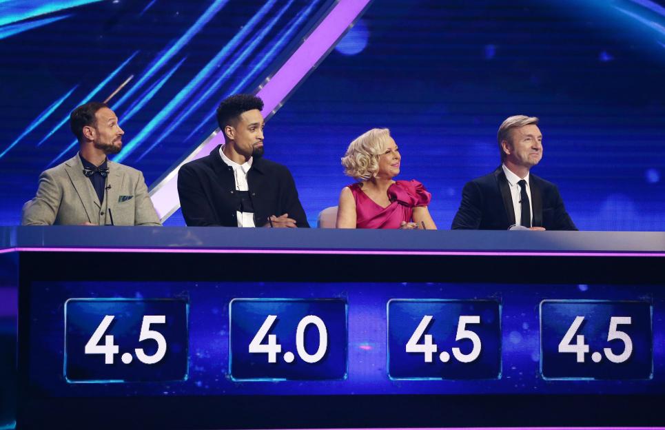 Judges Jason Gardiner, Ashley Banjo, Jayne Torvill, and Christopher Dean on the set of 'Dancing on Ice,' with their scores visible.