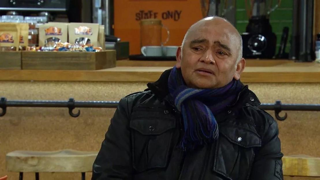Rishi Sharma of Coronation Street wearing a blue and purple striped scarf.