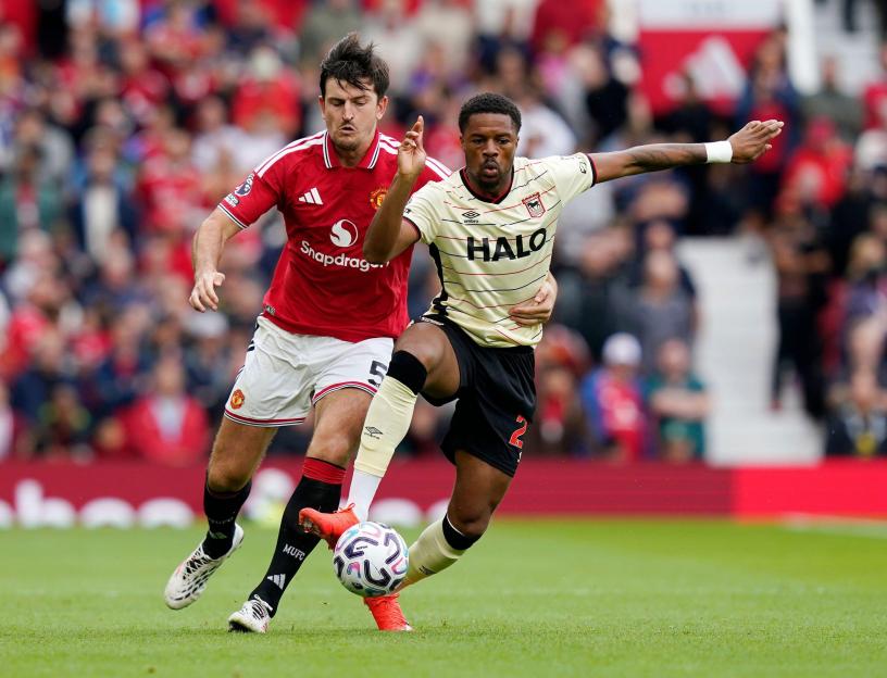 Harry Maguire of Manchester United tackles Chuba Akpom of Ipswich Town during a Premier League match.