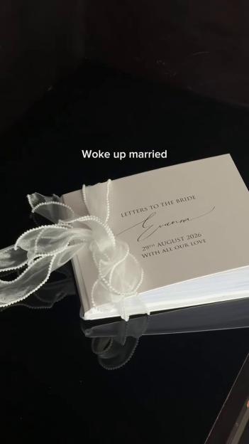 A white guestbook titled "Letters to the Bride Evanna" from August 29, 2026, tied with a white ribbon.