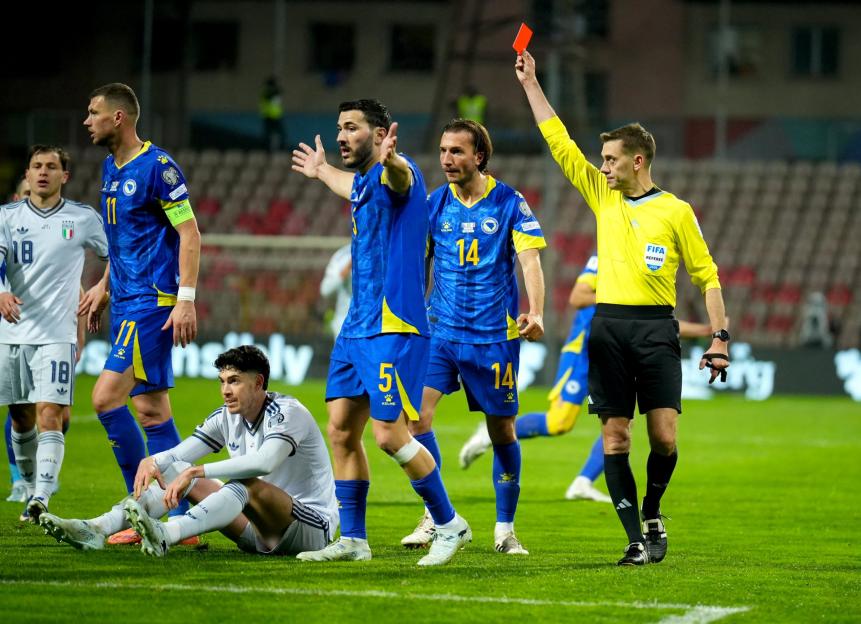 A referee holds up a red card during a FIFA World Cup 2026 European playoffs match between Bosnia and Herzegovina and Italy.