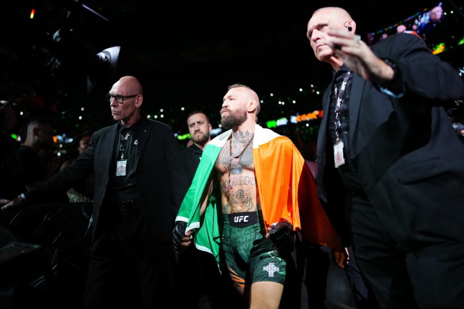 Conor McGregor, wrapped in an Irish flag, walks to the octagon at UFC 329.