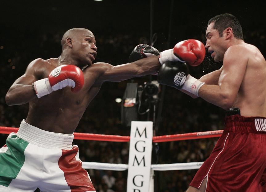 Floyd Mayweather Jr. punching Oscar De La Hoya in a boxing match.