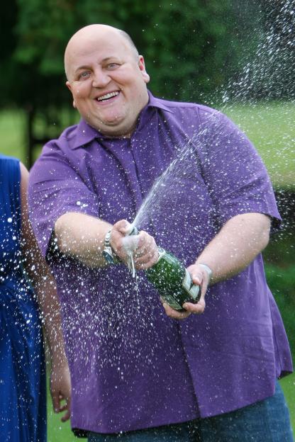 Lottery winner Adrian Bayford spraying champagne.
