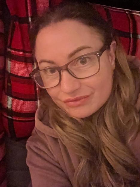 Sarah Tragner wearing a white beanie and glasses.