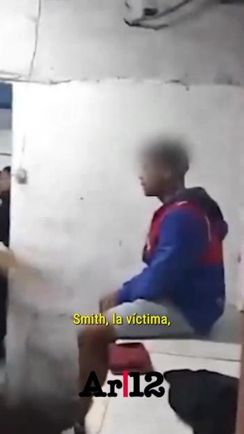 Person identified as "Smith, the victim" sits in a room with white walls, facing right.